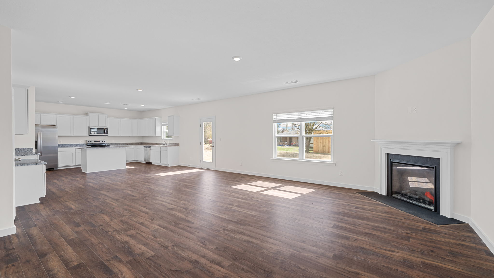 great room with solid flooring and fireplace