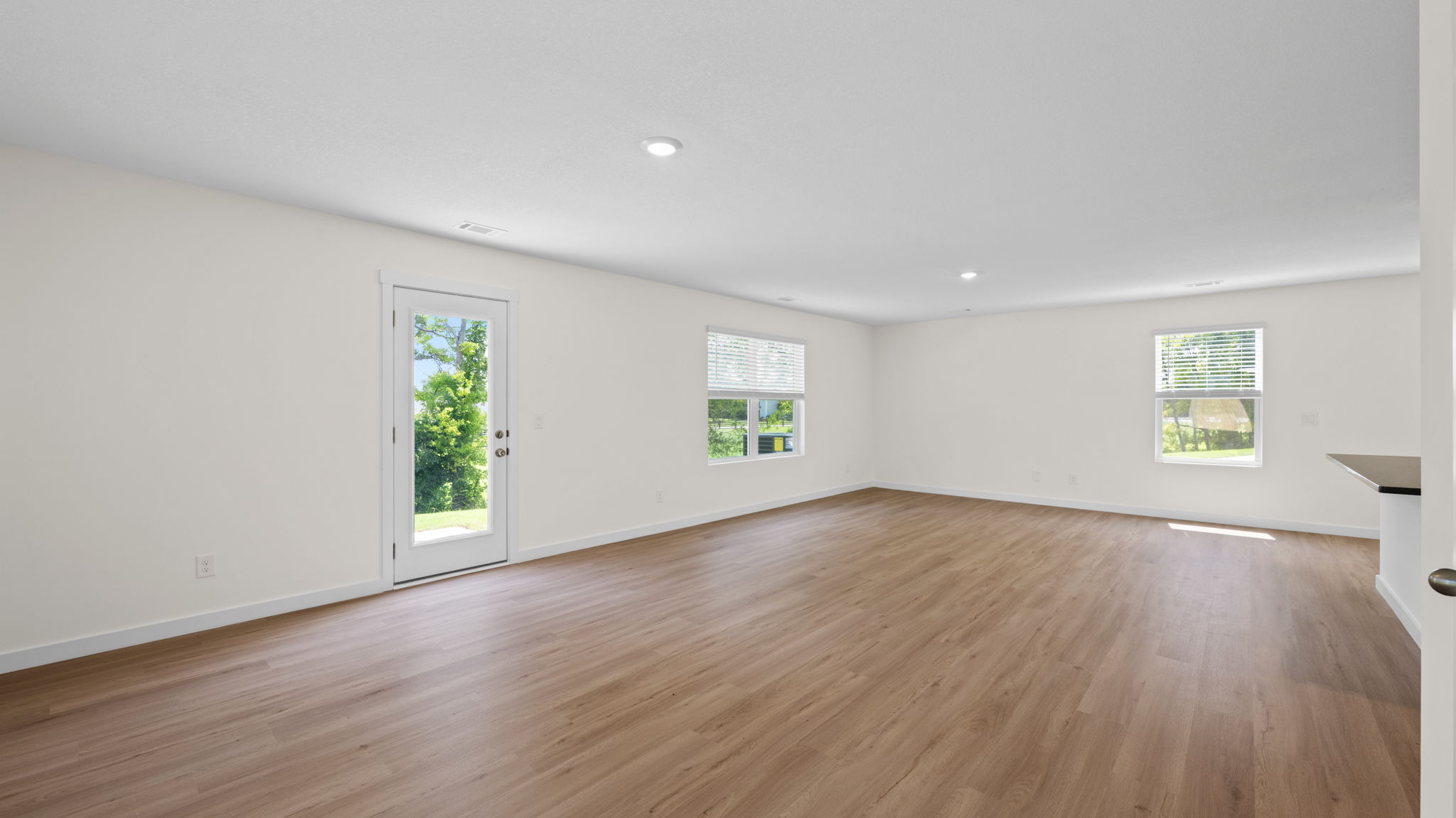 open concept living room with windows and back door