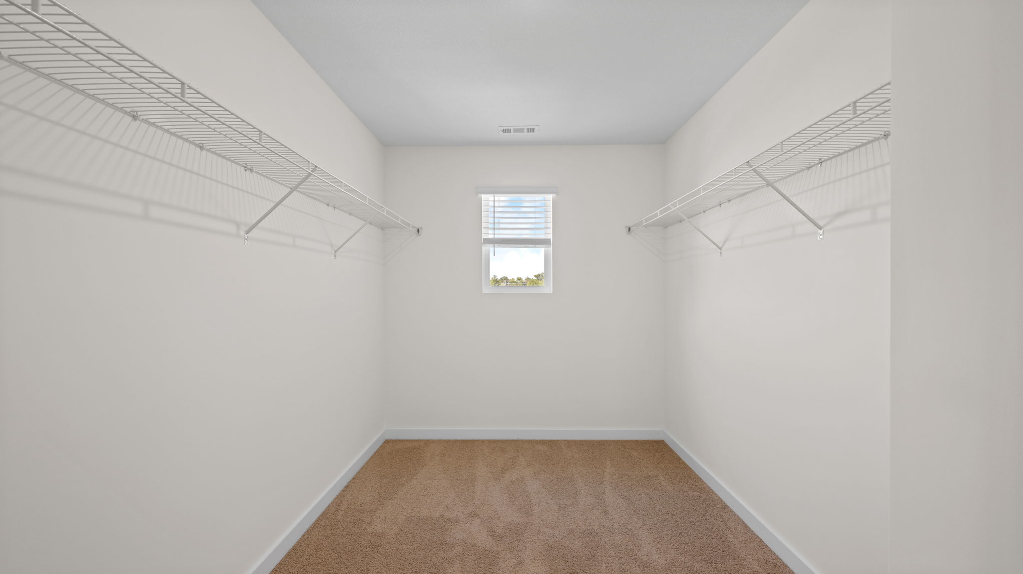 primary bedroom walk in closet with window