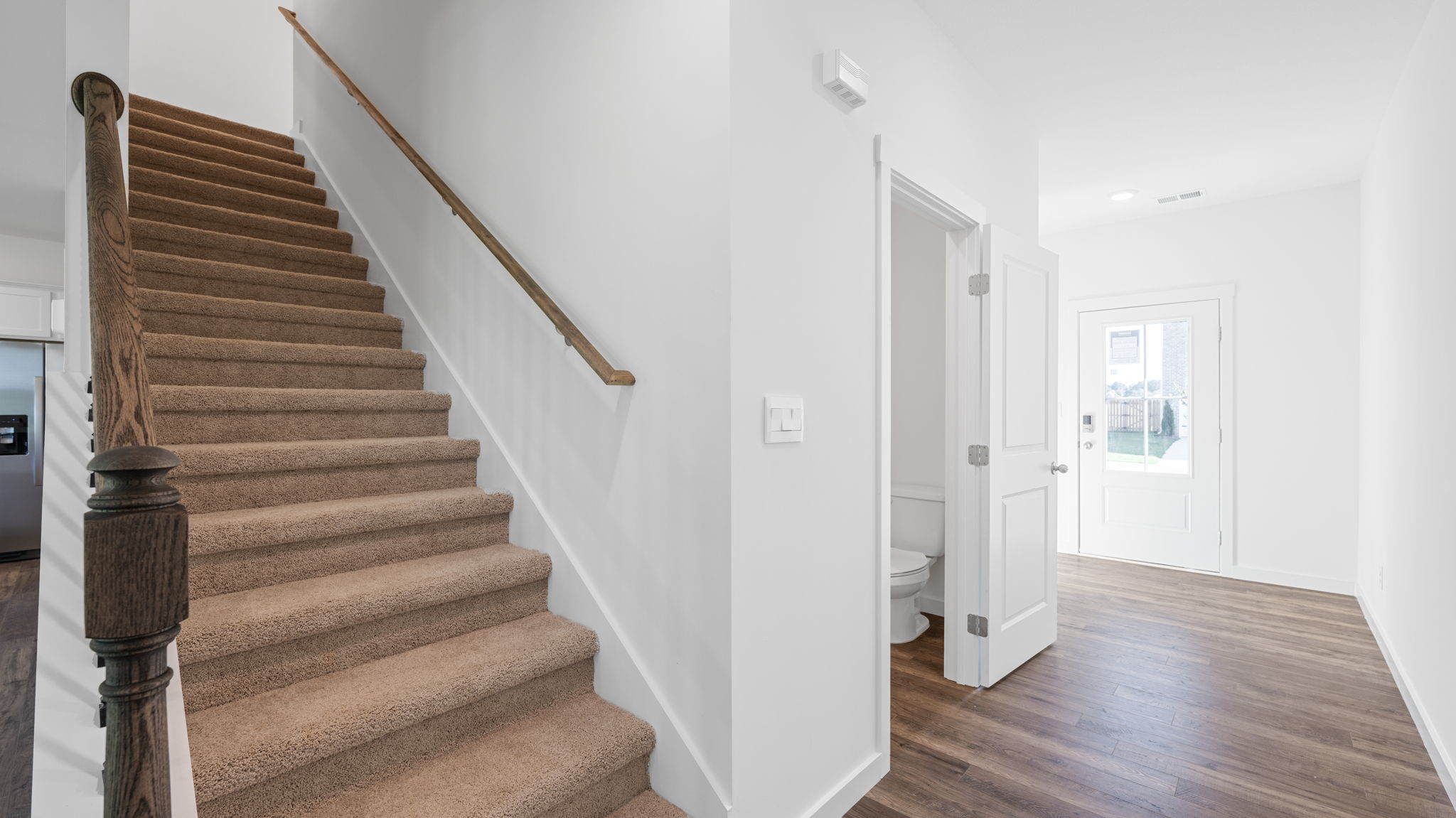 Stairs to second floor off entry hallway of home