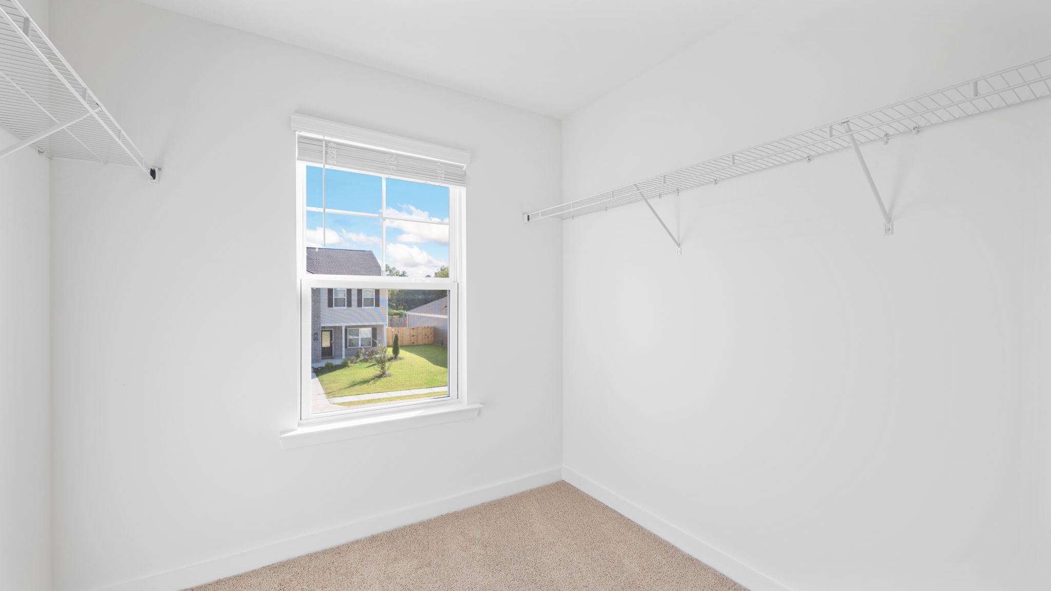 Primary closet with single window and shelving