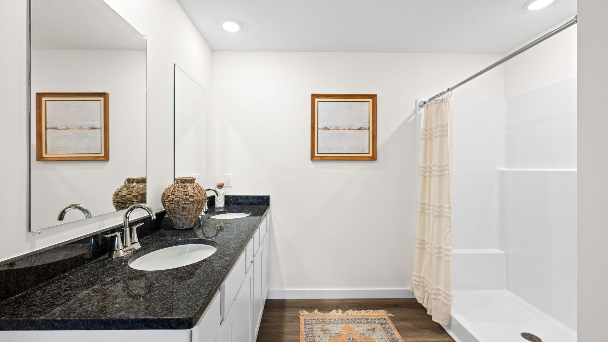 primary bathroom with double vanity and walk-in shower