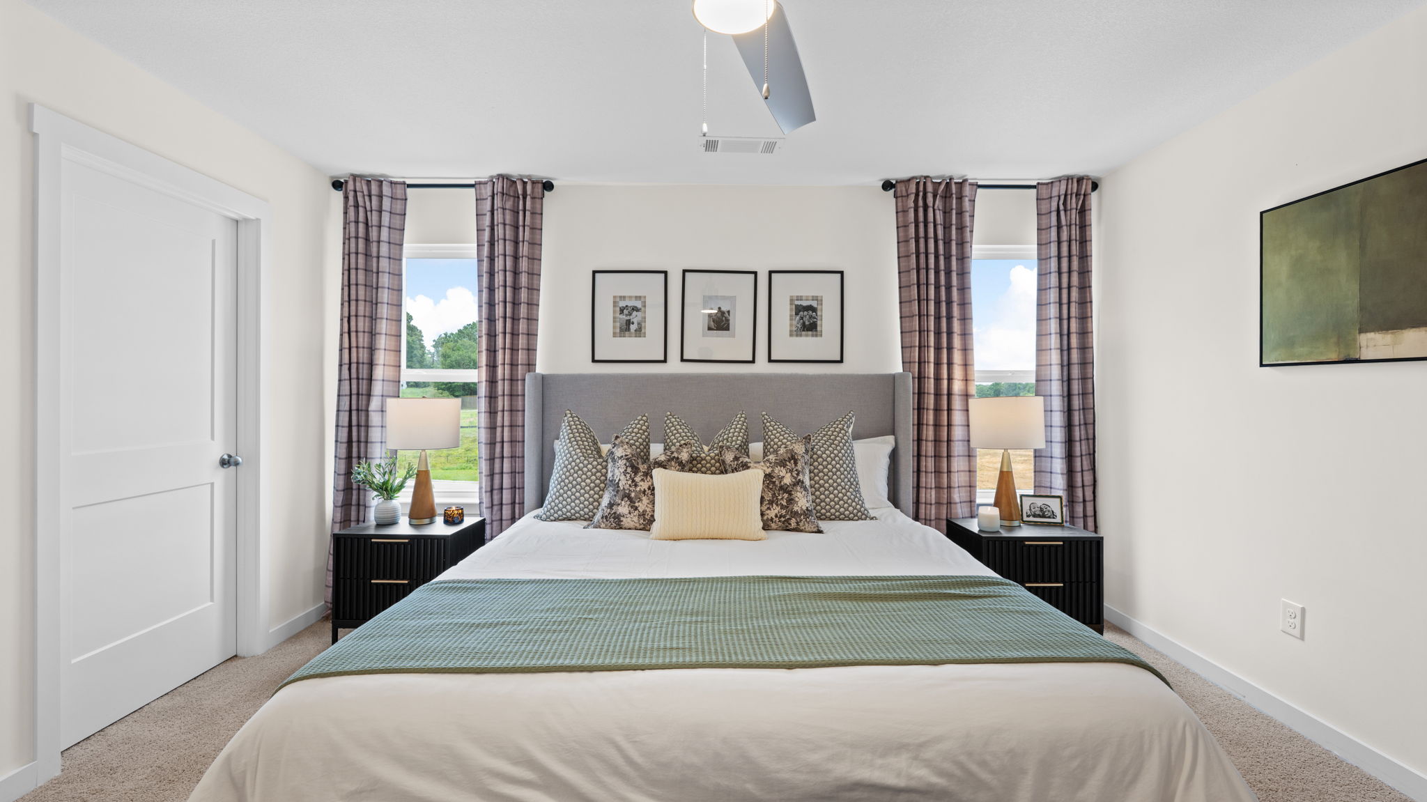 primary bedroom with double windows and carpet