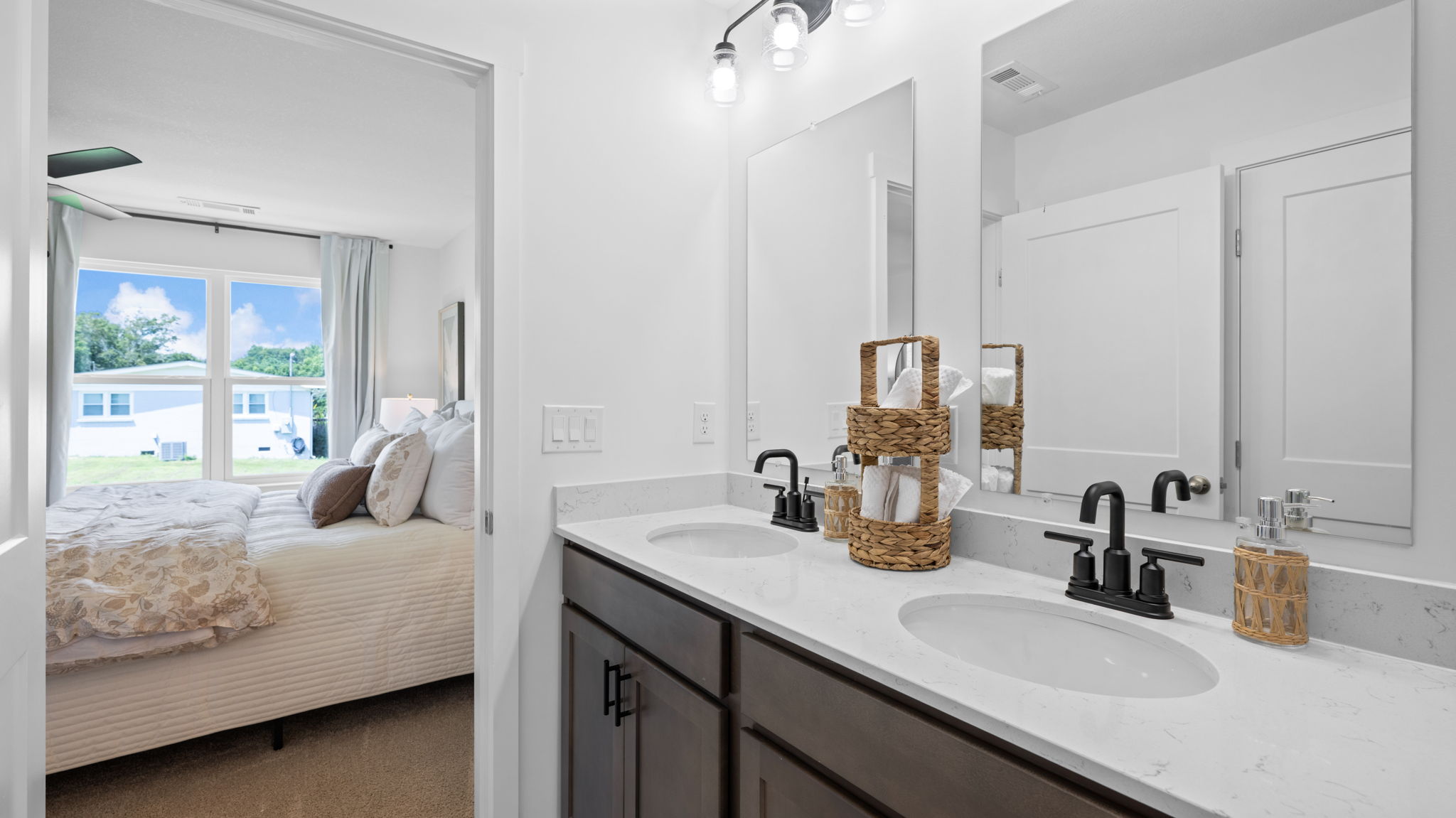 bathroom with double sink and bedroom