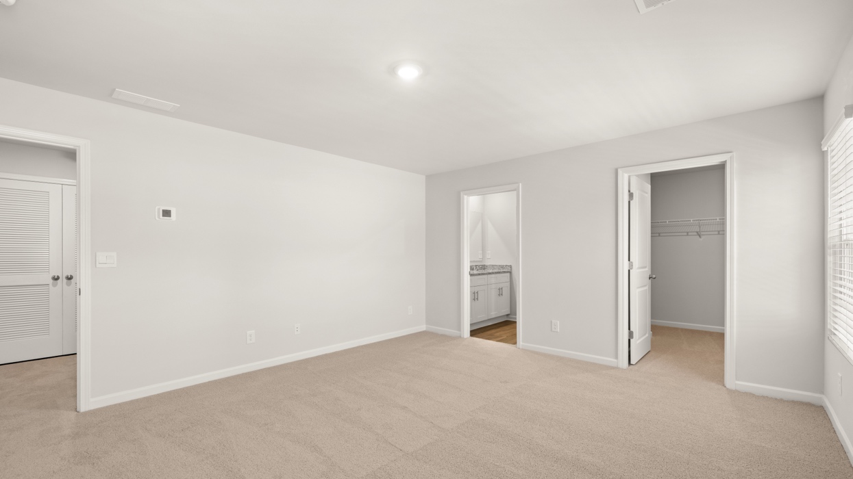 primary bedroom with two single windows and en suite