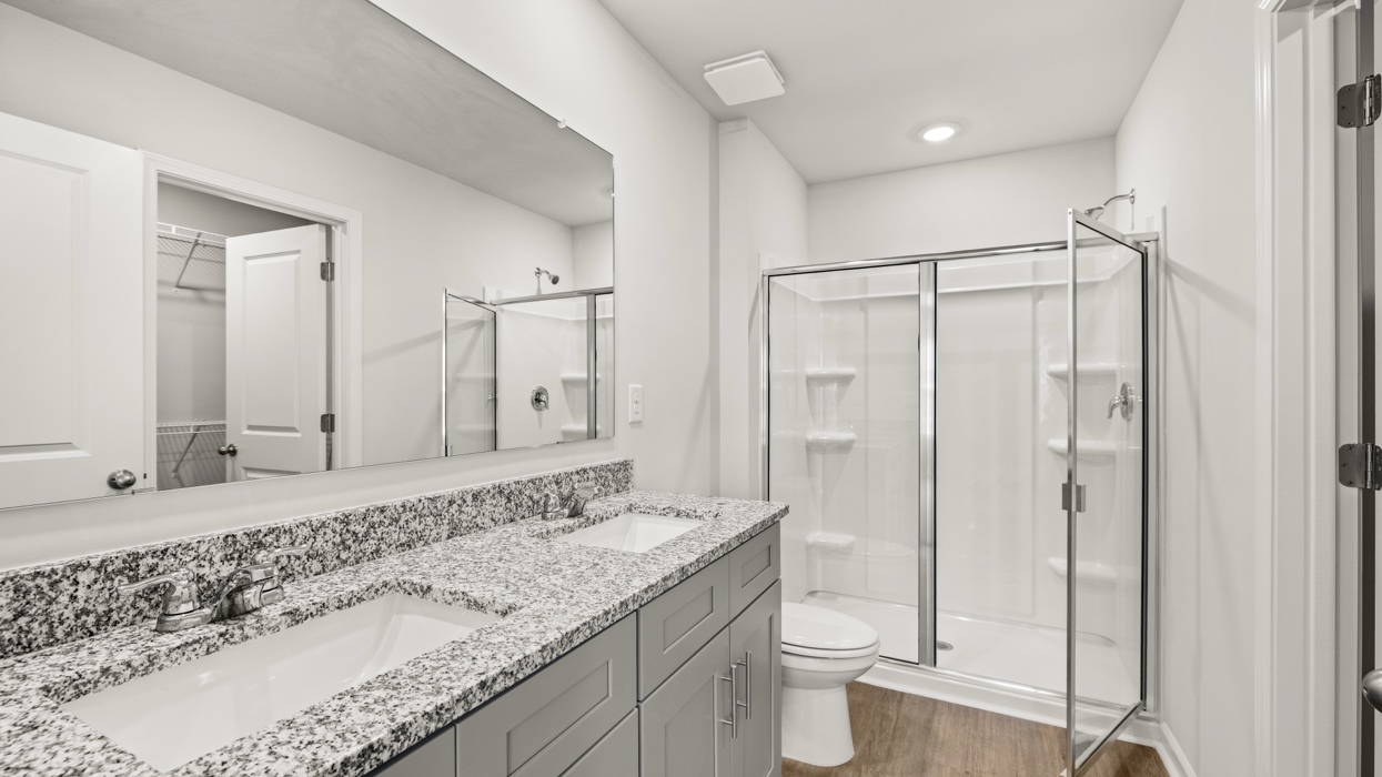 primary bathroom with double vanity and walk-in shower
