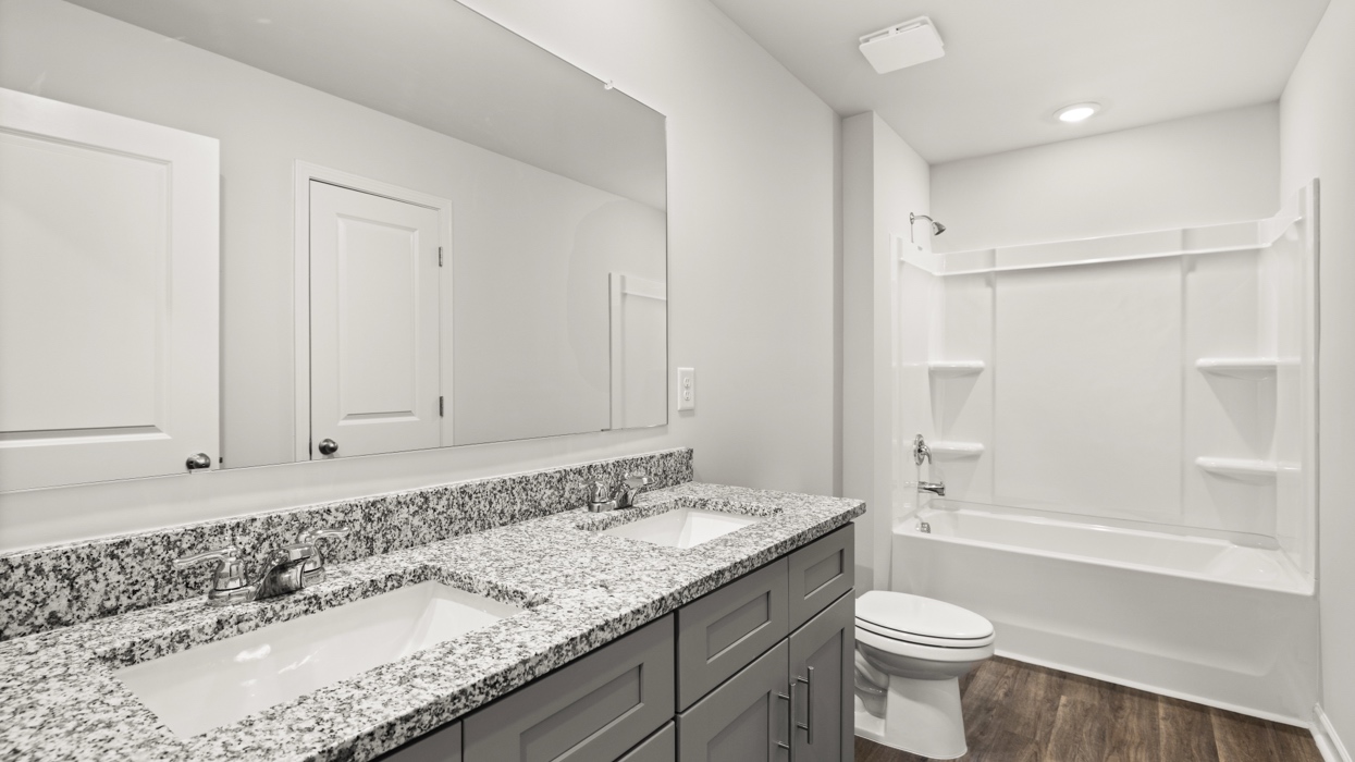 full bathroom with double vanity and shower/ tub duo