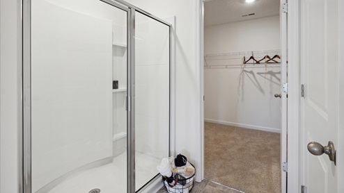 Glass shower in primary bathroom and walk in closet