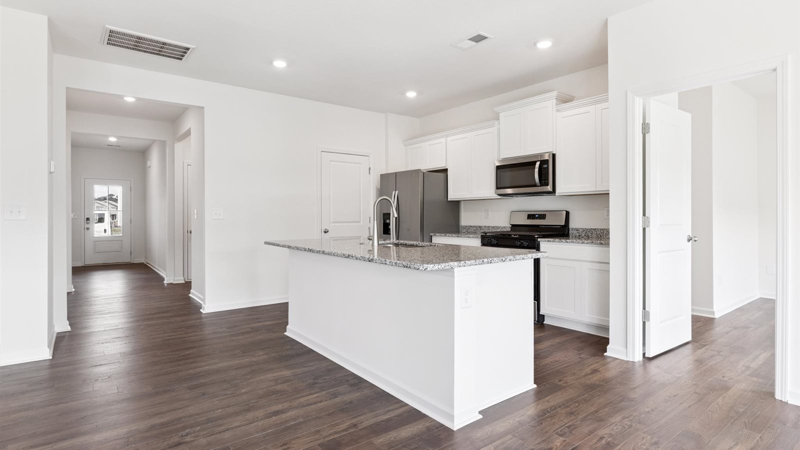 kitchen with granite, kitchen island, stainless steel appliances and white cabinets