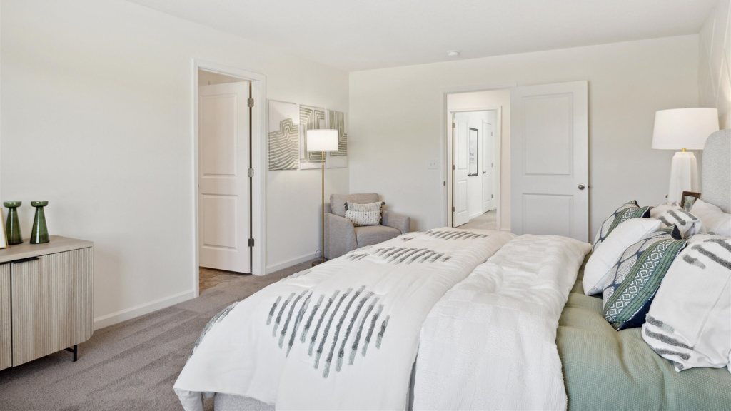 Primary bedroom with plush carpet floors and double light allowing windows
