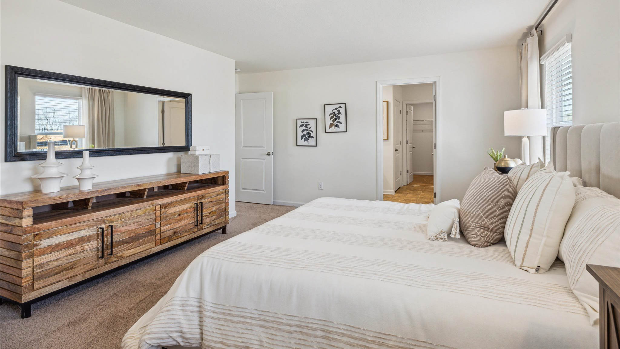 Primary bedroom with plush carpet floors and double light allowing windows