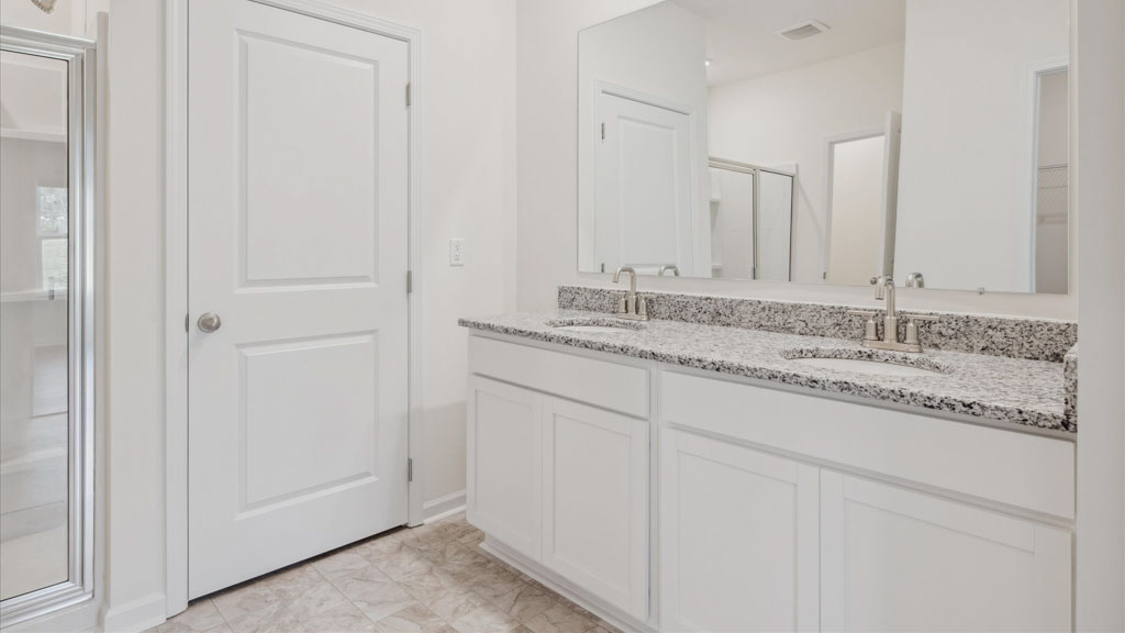 Primary bathroom with double vanity and walk-in shower