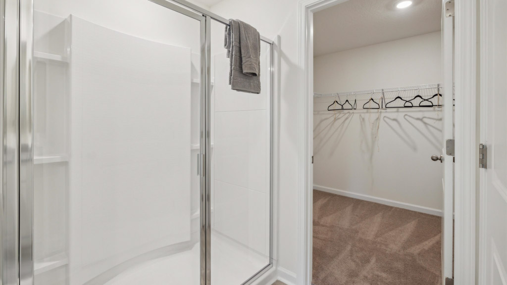 Primary bedroom with private attached bathroom and walk-in closet