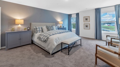 primary suite with white wall and one blue accent wall