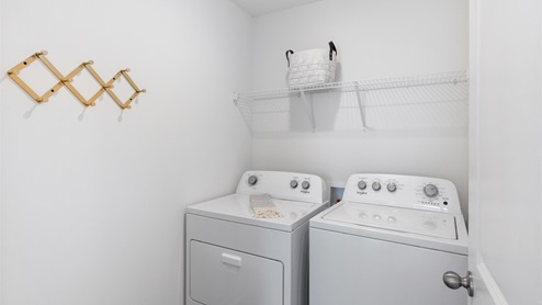 Laundry room with wire shelving over appliances