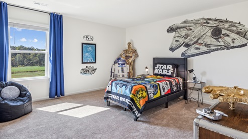 Bedroom with blue bedspread and space wall graphics