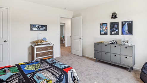 Bedroom with blue bedspread and dresser
