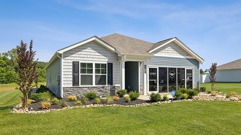 Side exterior of one level home with white shake and gray stone