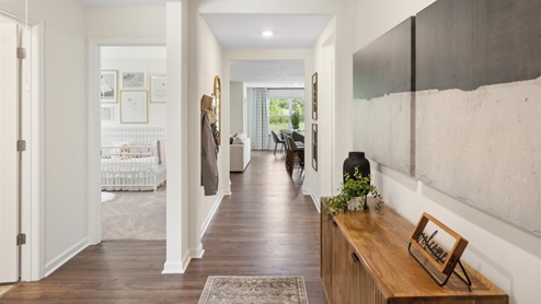 Entry hallway of home with dark brown RevWood flooring and wooden hallway table