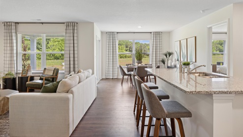 Open concept living and kitchen space with kitchen island and white couch