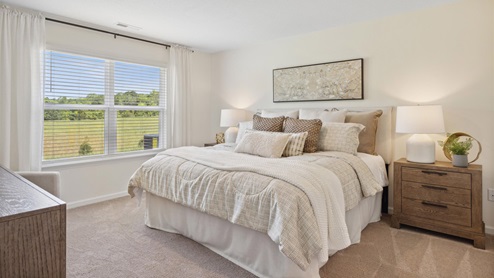 Primary bedroom decorated in a neutral color palette and large double windows