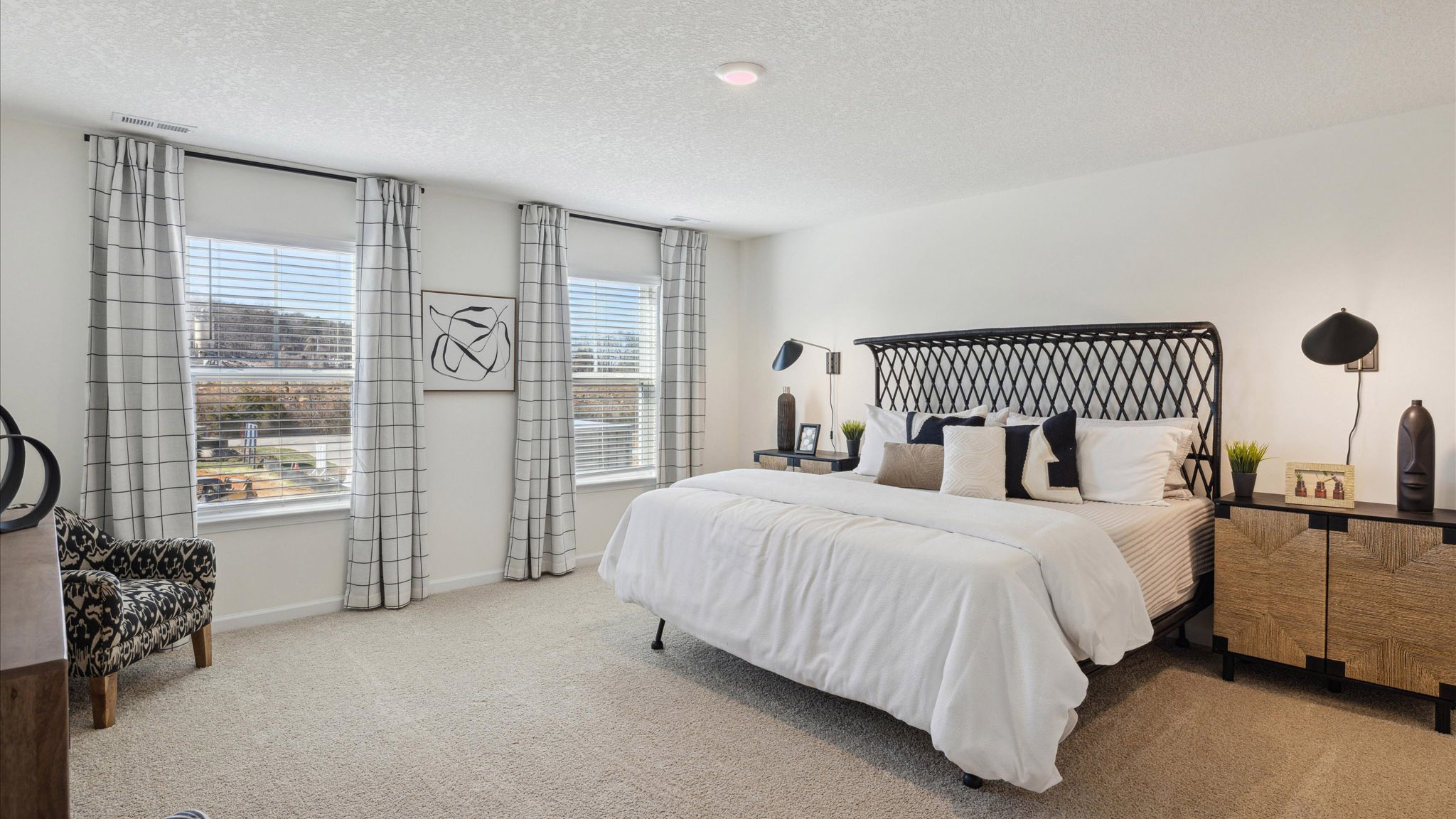 Primary bedroom with plush carpet floors and double light allowing windows