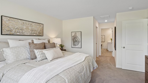 Primary bedroom with view of ensuite bathroom and walk in closet