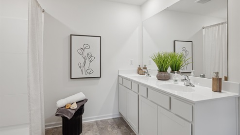 Primary bathroom with white cabinets and a double vanity