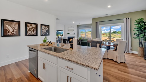 Spacious kitchen with white cabinetry, large island and stainless steel appliances