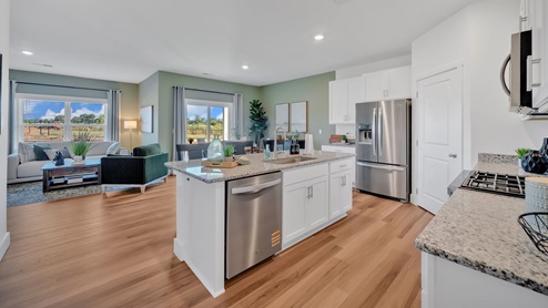 Spacious kitchen with white cabinetry, large island and stainless steel appliances