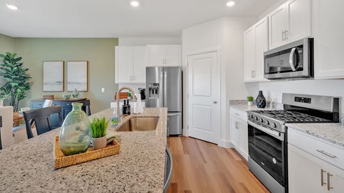 Spacious kitchen with white cabinetry, large island and stainless steel appliances