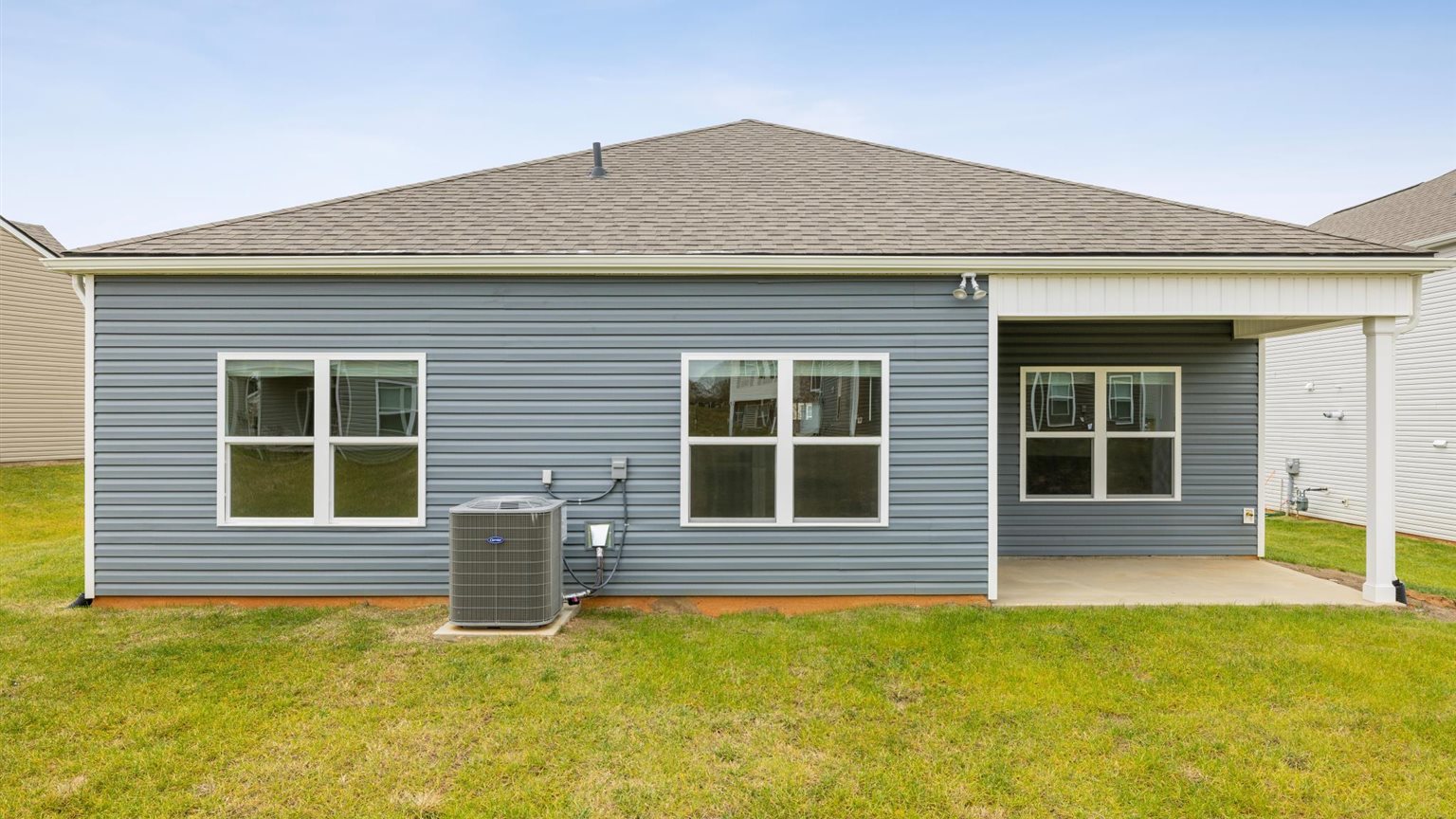 Back exterior of traditional two story home with vinyl and board and batten