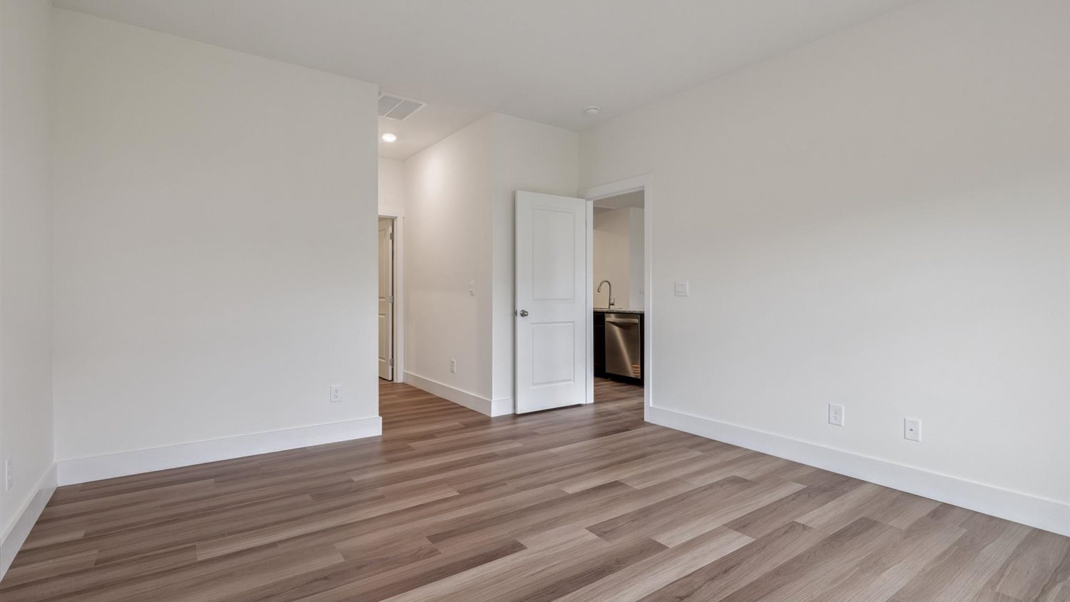 Primary bedroom with private attached bathroom and walk-in closet