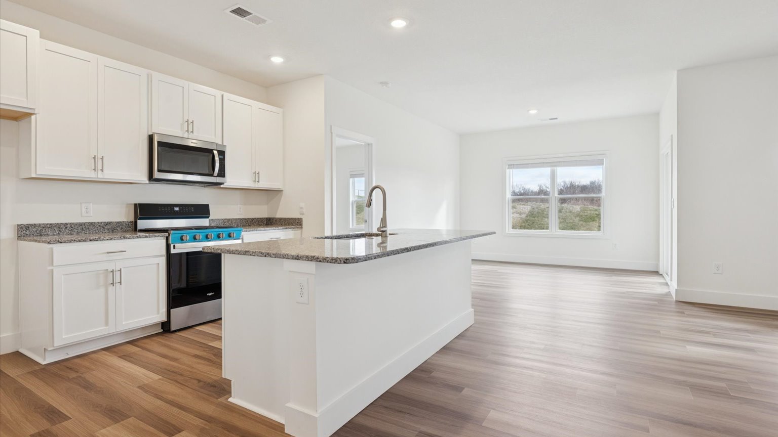 Kitchen with stainless steel appliances, shaker style cabinets, and elevated finishes