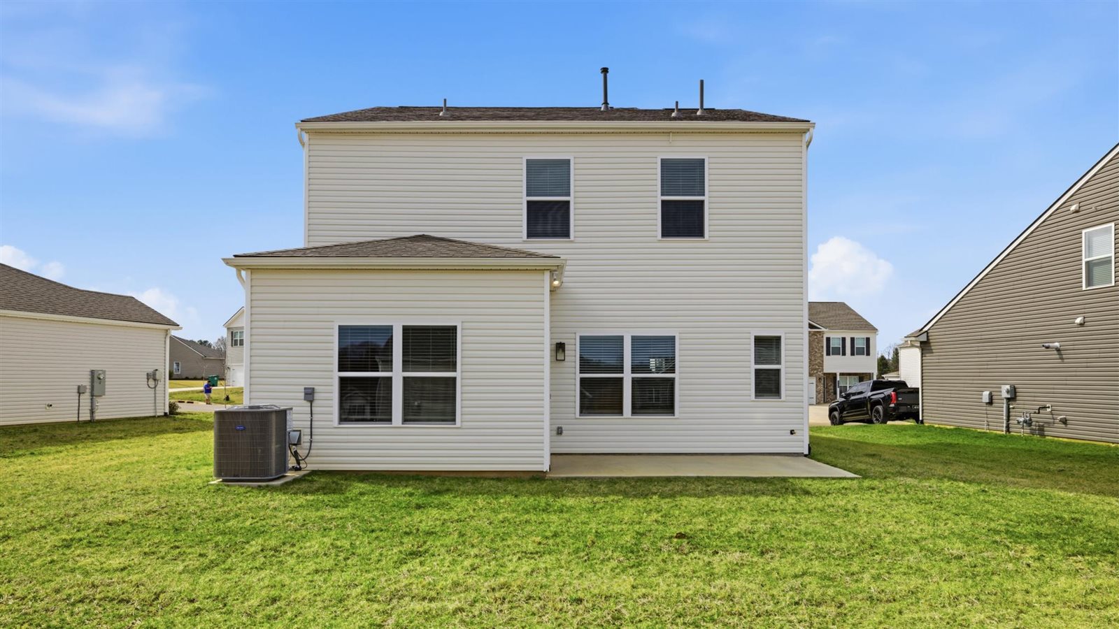 rear exterior of home and sodded yard