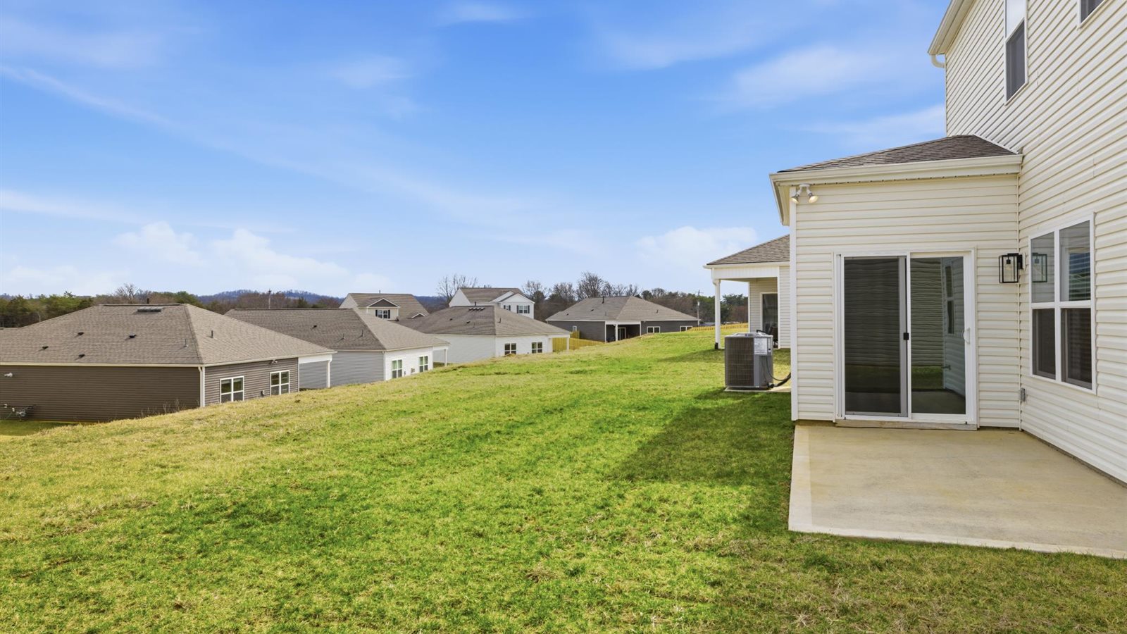 rear exterior of home with patio and sodded yard