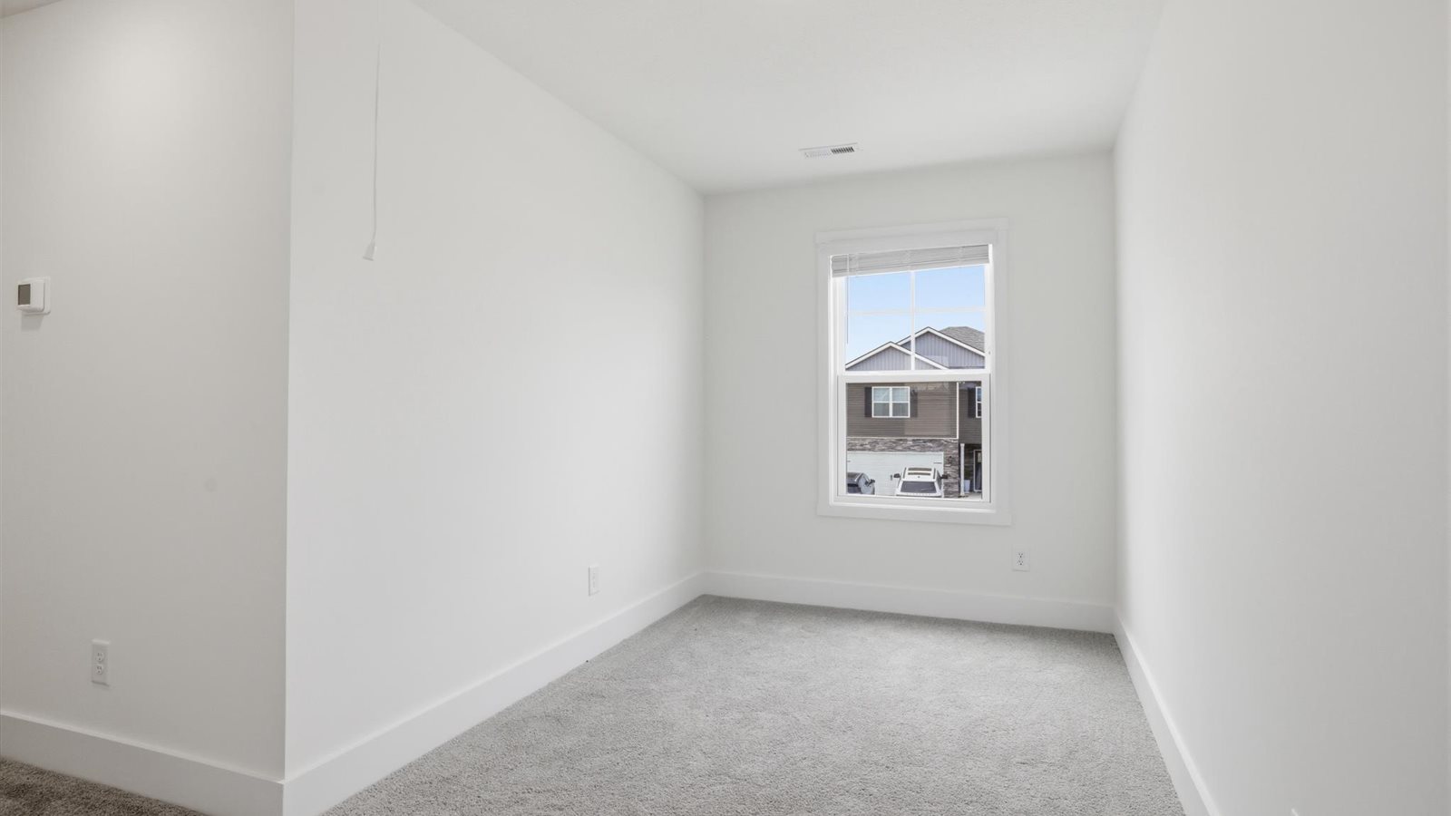 upstairs landing area with carpet and large window for additional natural light