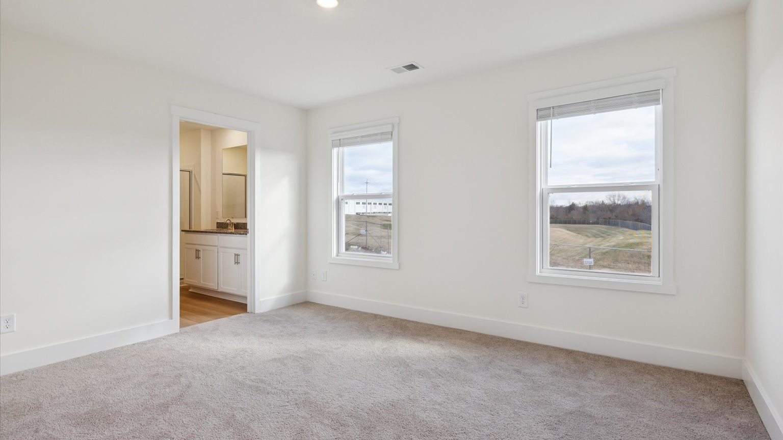 Primary bedroom with private attached bathroom and walk-in closet