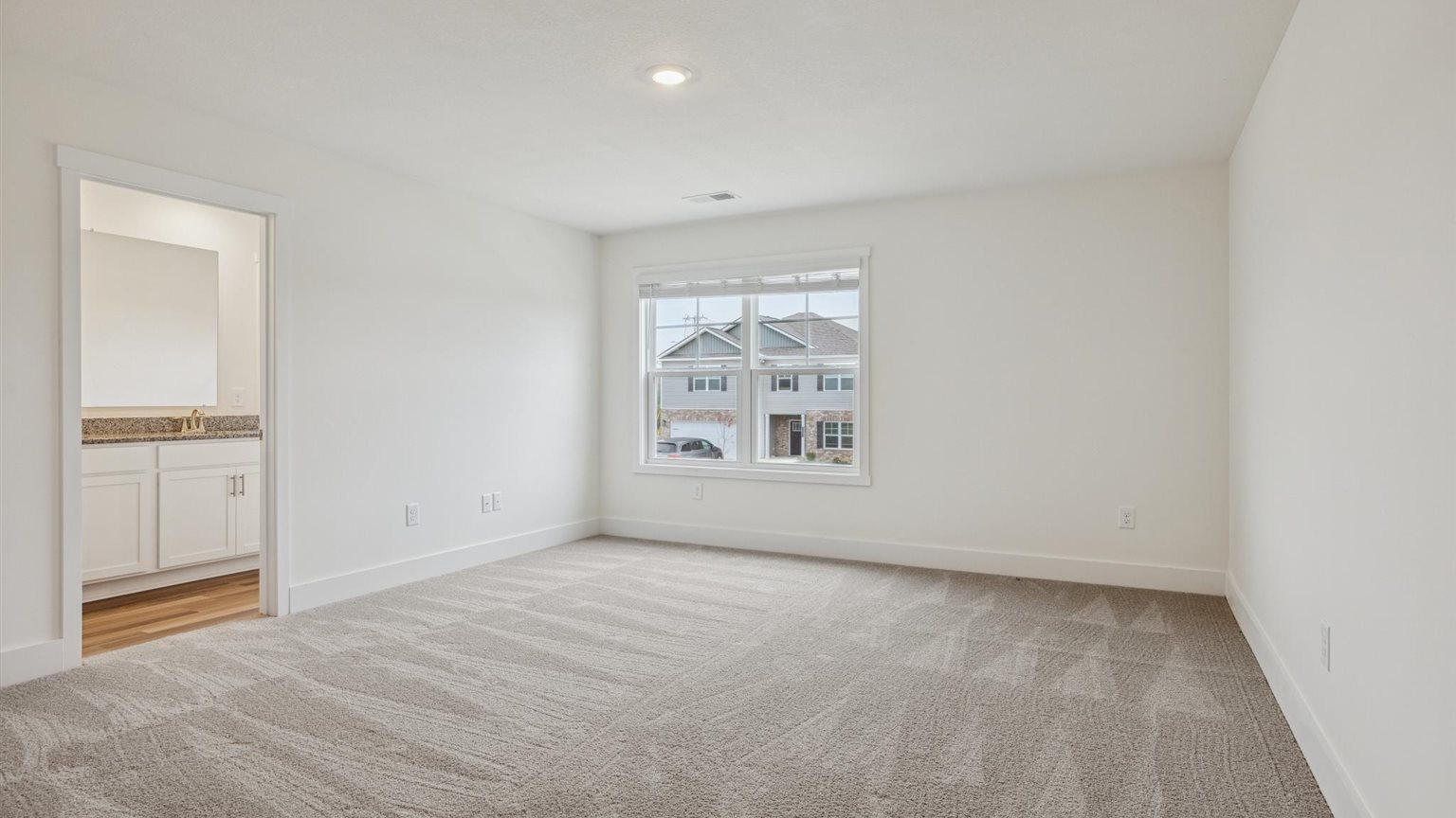 Primary bedroom with private attached bathroom and walk-in closet