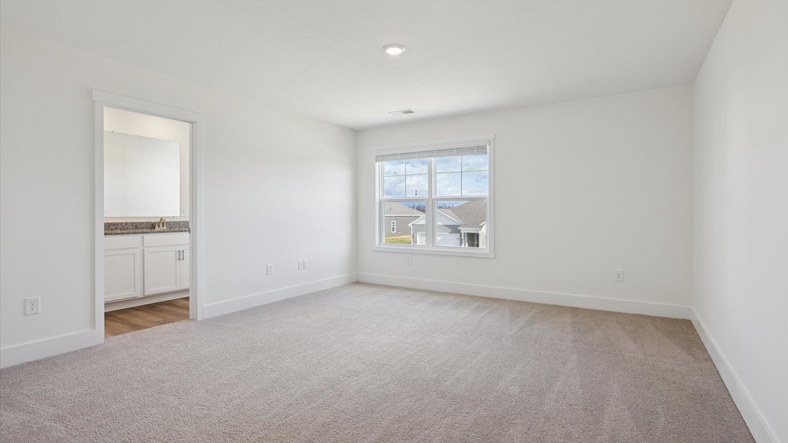 Primary bedroom with private attached bathroom and walk-in closet