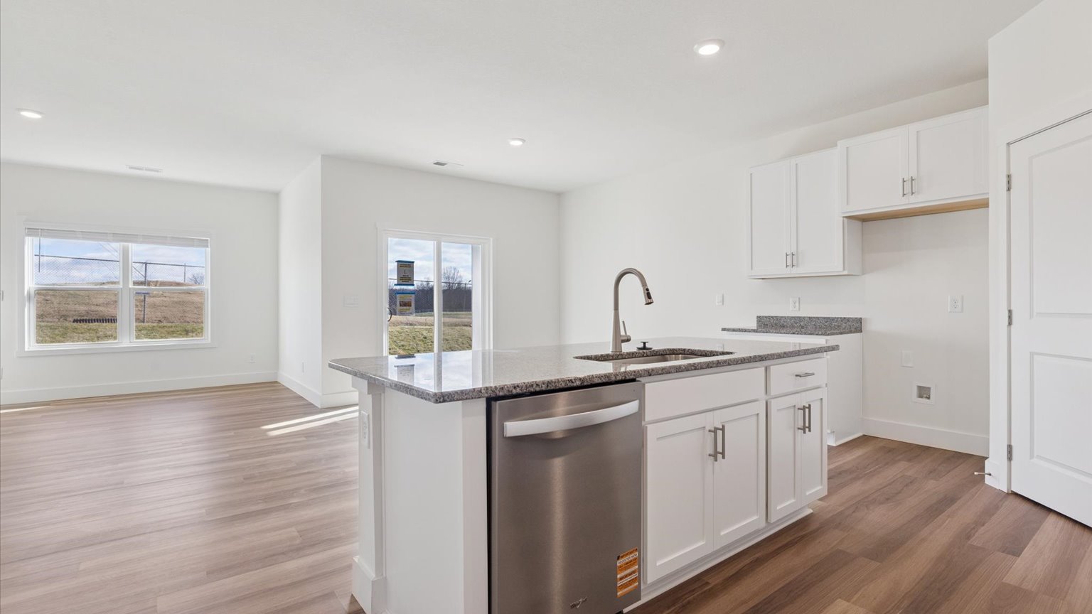 Kitchen with quartz counterops, stainless steel appliances, and shaker style cabinets