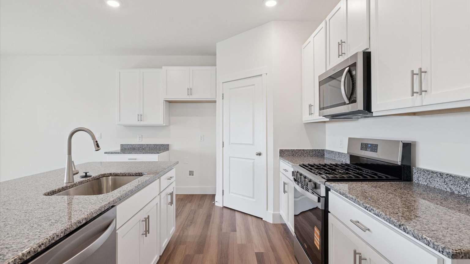 Kitchen with quartz counterops, stainless steel appliances, and shaker style cabinets
