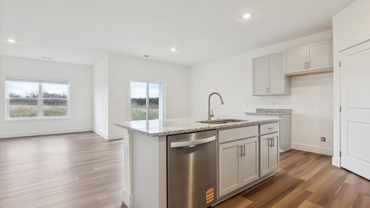 Kitchen with quartz counterops, stainless steel appliances, and shaker style cabinets