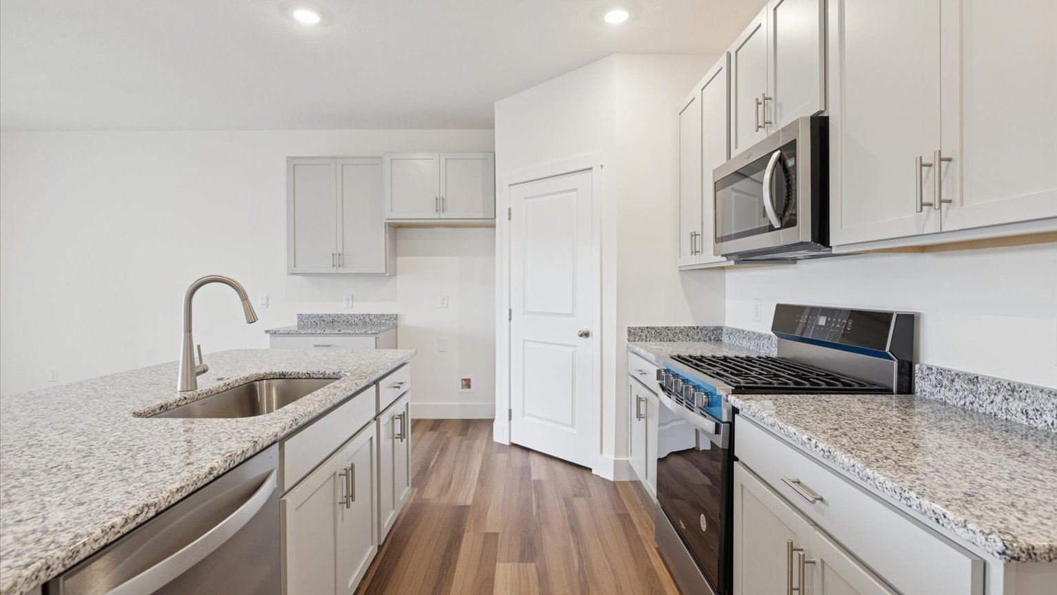 Kitchen with quartz counterops, stainless steel appliances, and shaker style cabinets