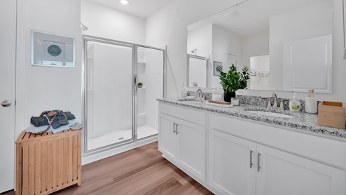 bathroom with dual vanity sinks, toilet, bath tub and a walk in shower