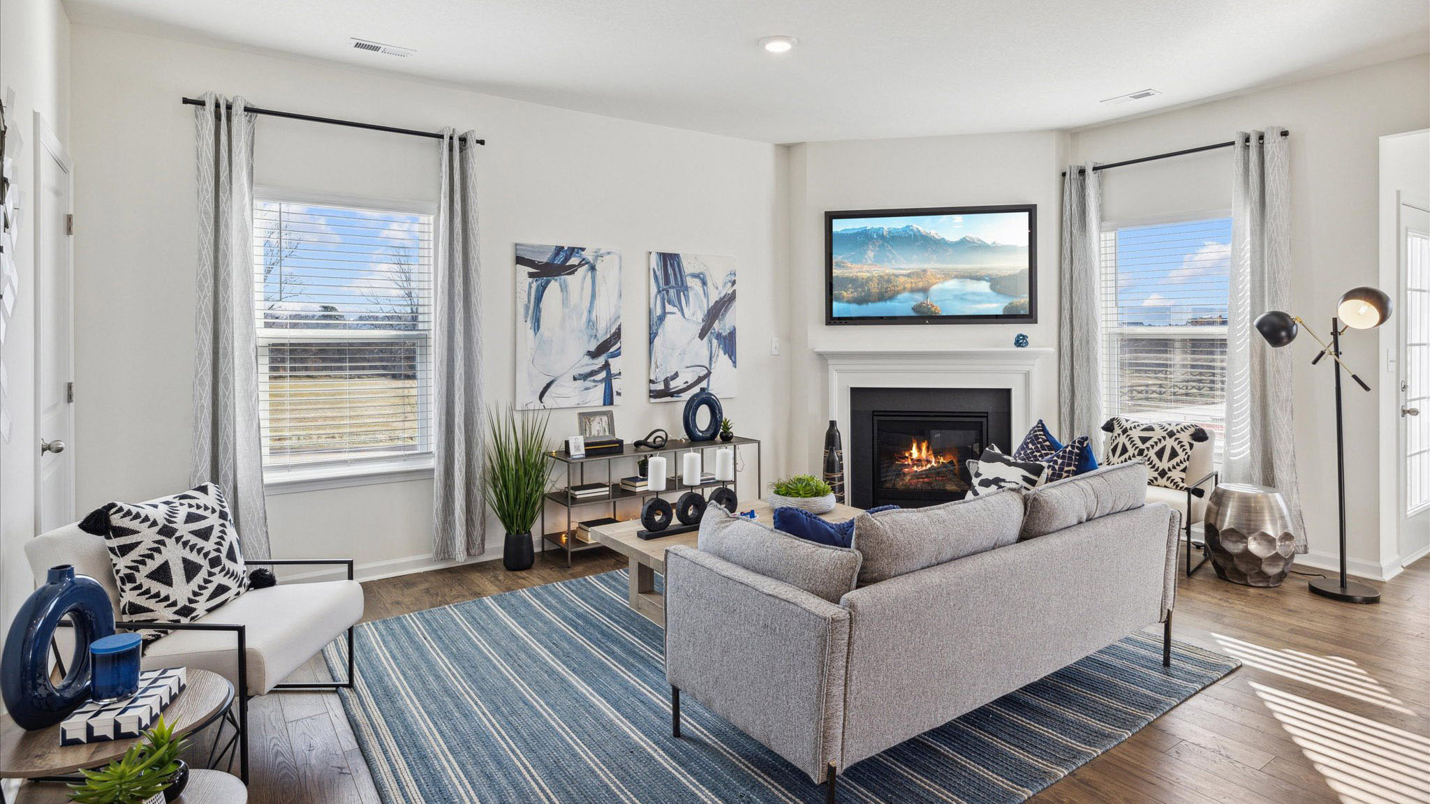 Living area with two windows, tile floors, and a fireplace.