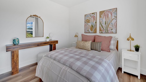 bedroom with a large window, bed and white night stand