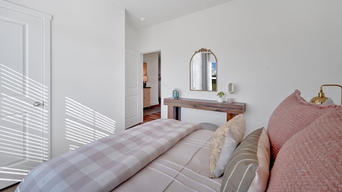 bedroom with a large window, bed and white night stand