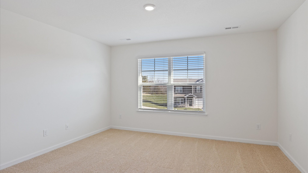 Primary bedroom with plush carpet floors and double light allowing windows