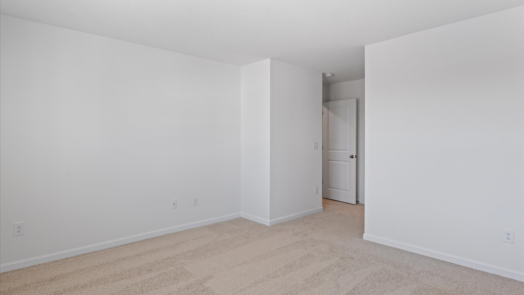 Primary bedroom with plush carpet floors and double light allowing windows